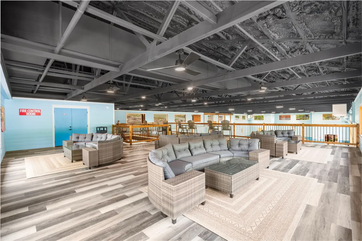 A cozy seating area with modern décor and large windows, creating a casual, welcoming spot for socializing, reading, or simply enjoying the natural surroundings. Soft furnishings and contemporary touches highlight comfort and style.